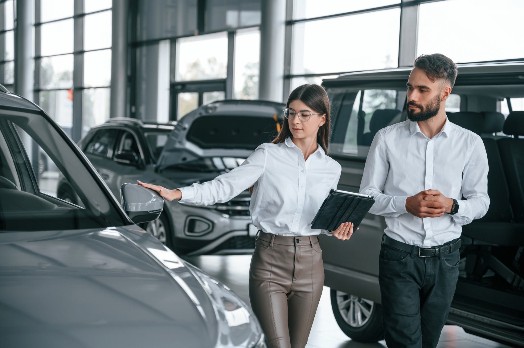 Ford Sales Team member showing customer selection of Ford vehicles in Ford showroom