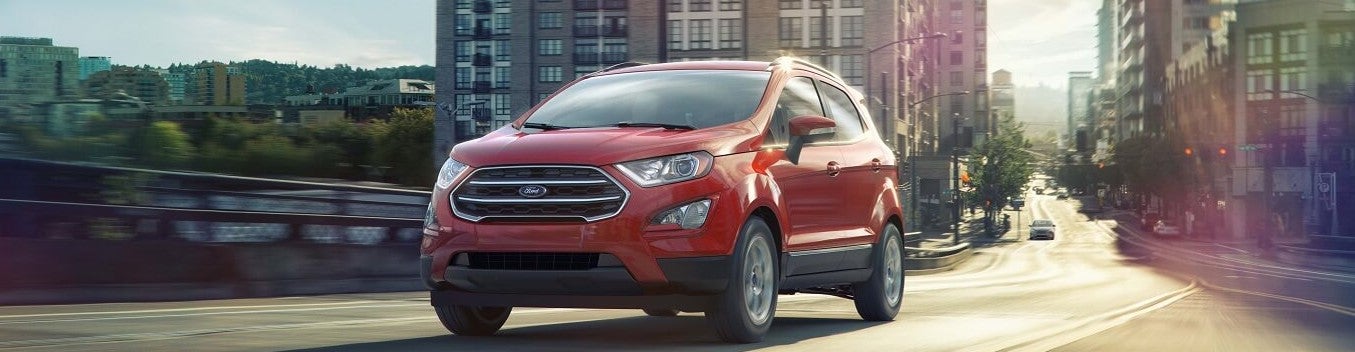 Used Ford Escape driving with city background