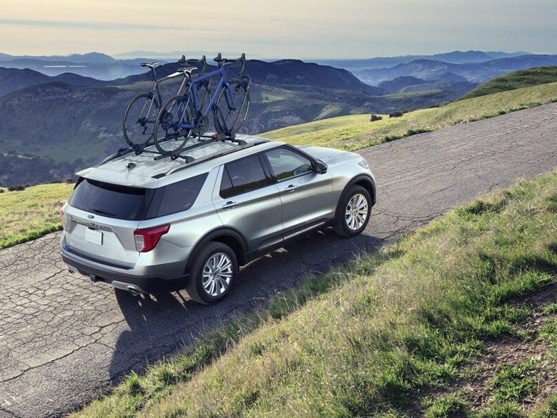 Used Ford Explorer on road with bikes on top rack