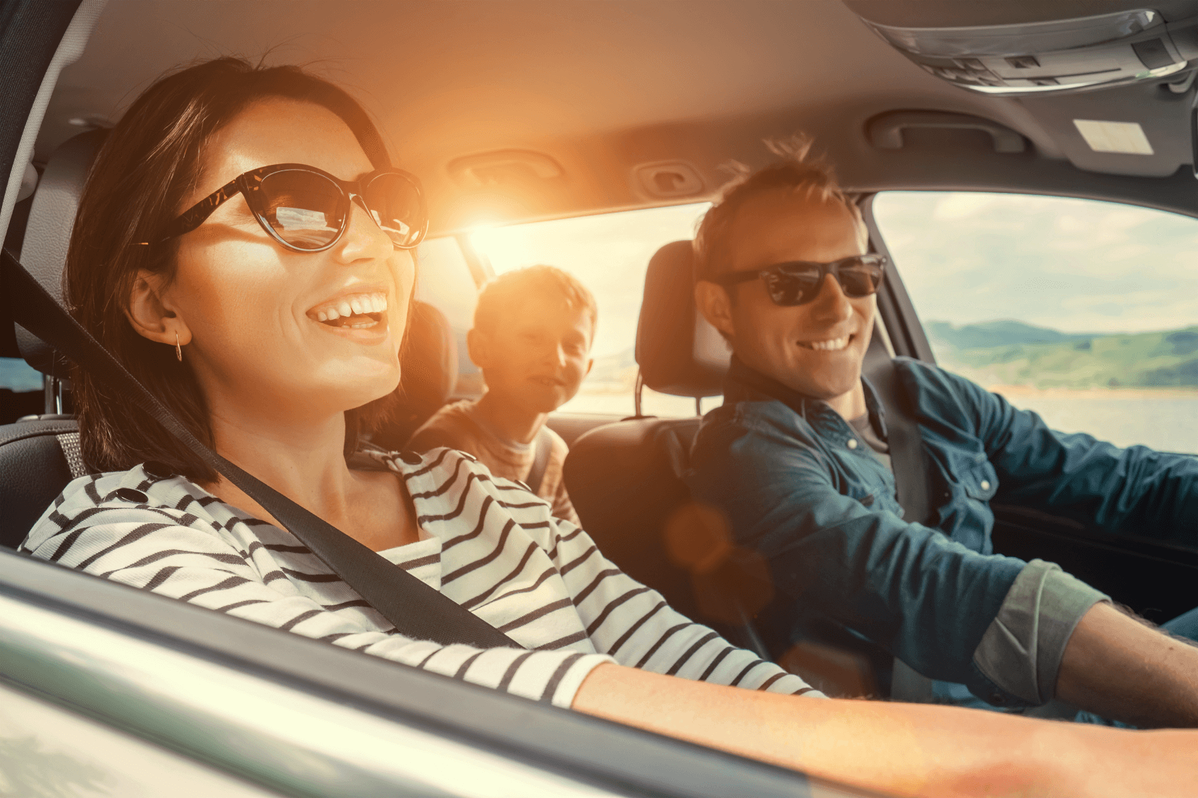 Family smiling in their Ford vehicle while exploring Carlsbad CA