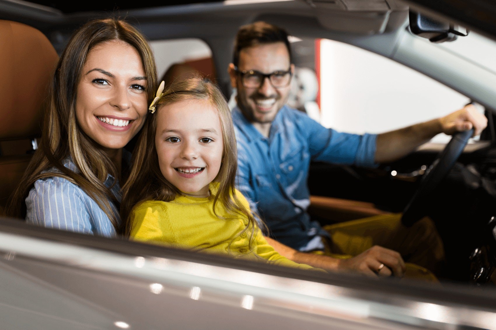 Family smiling in their new Ford vehicle