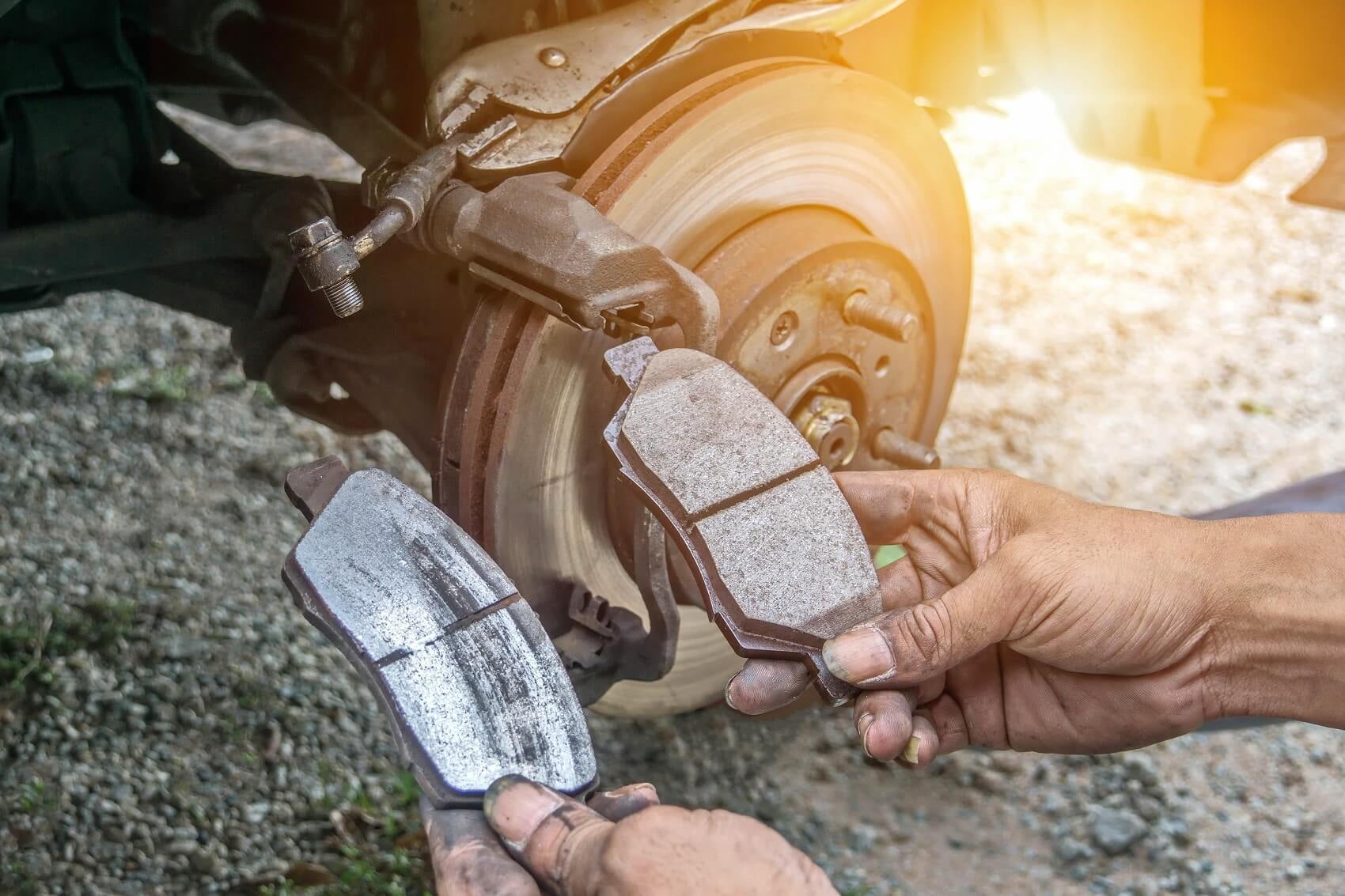 Ford Certified Technician holding two brakes to show the difference as a sign of when a brake repair is needed
