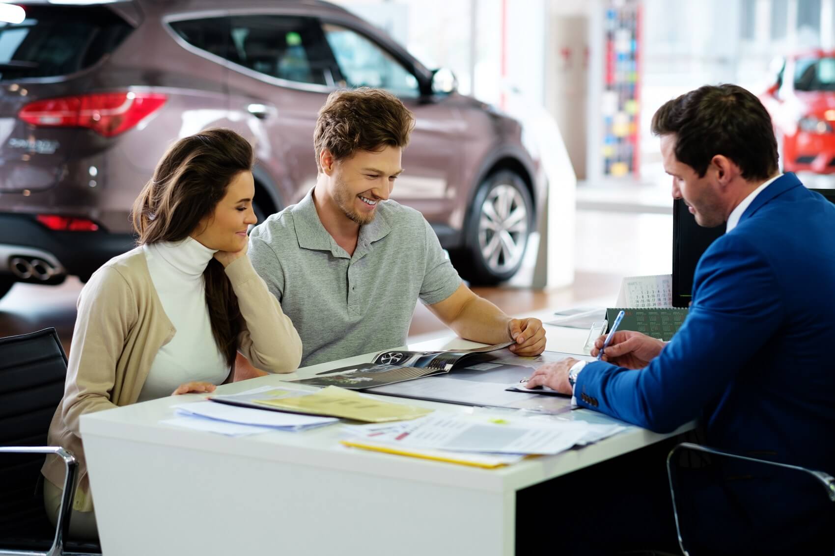 Couple reviewing paperwork with Ford Finance Team member - Used Car Dealer Vista CA
