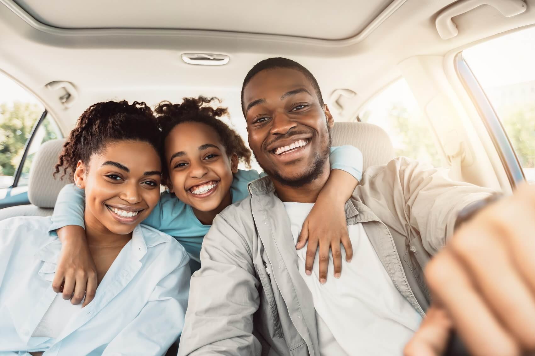 Family sitting in their Ford F-150 smiling at camera after getting a Ford F-150 Lease Deal