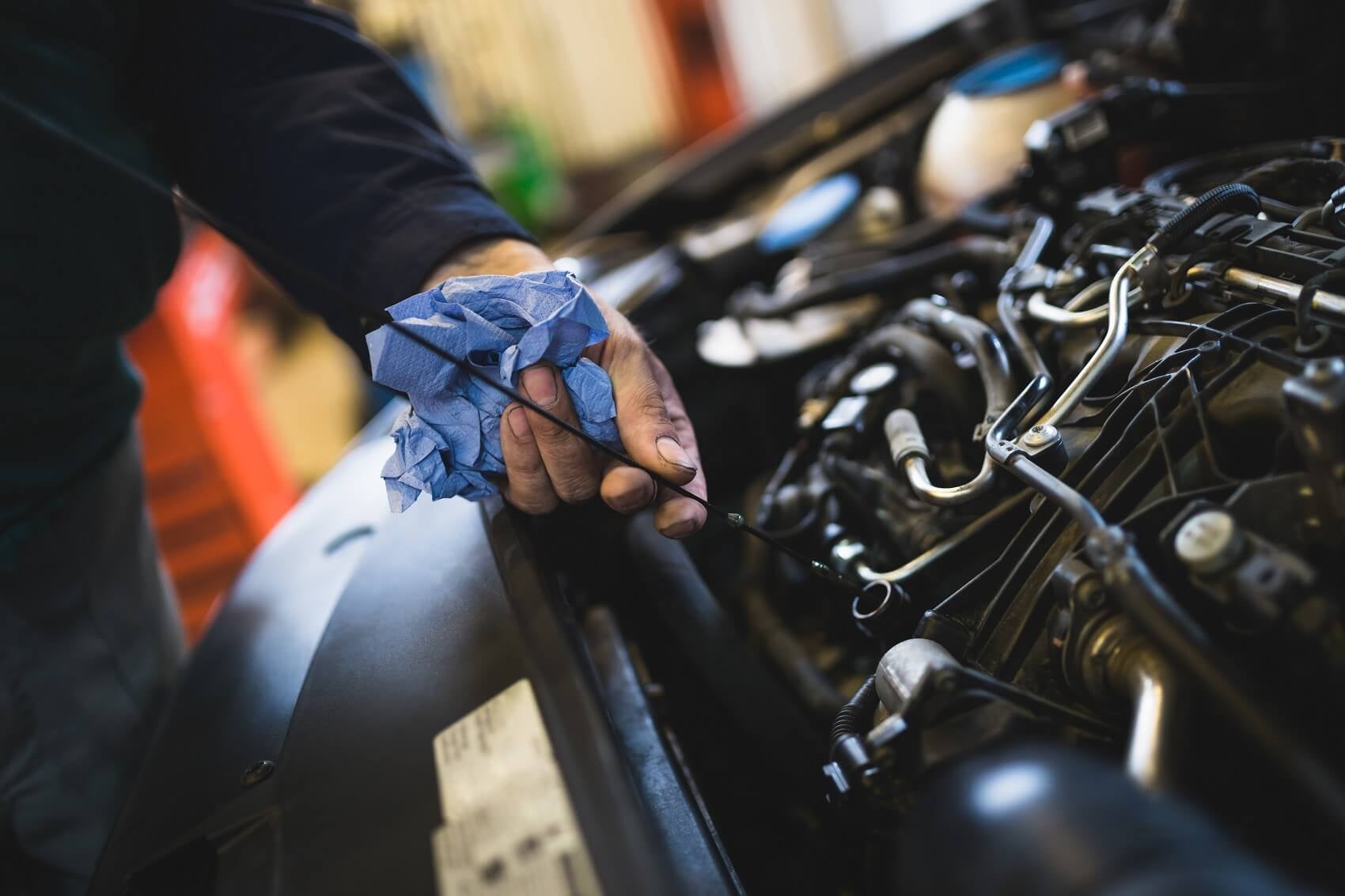 Ford Certified Technician checking oil levels while servicing a Ford vehicle