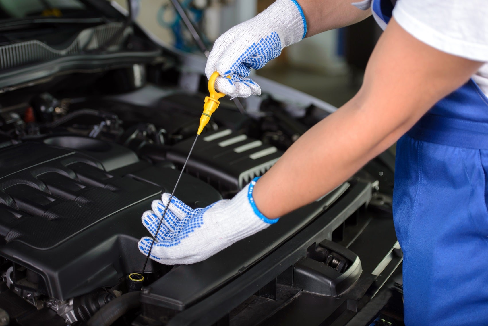 Ford Certified Technician checking oil level in vehicle during oil change